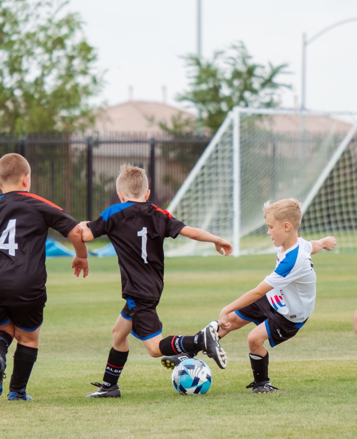 Children playing football on a soccer field.