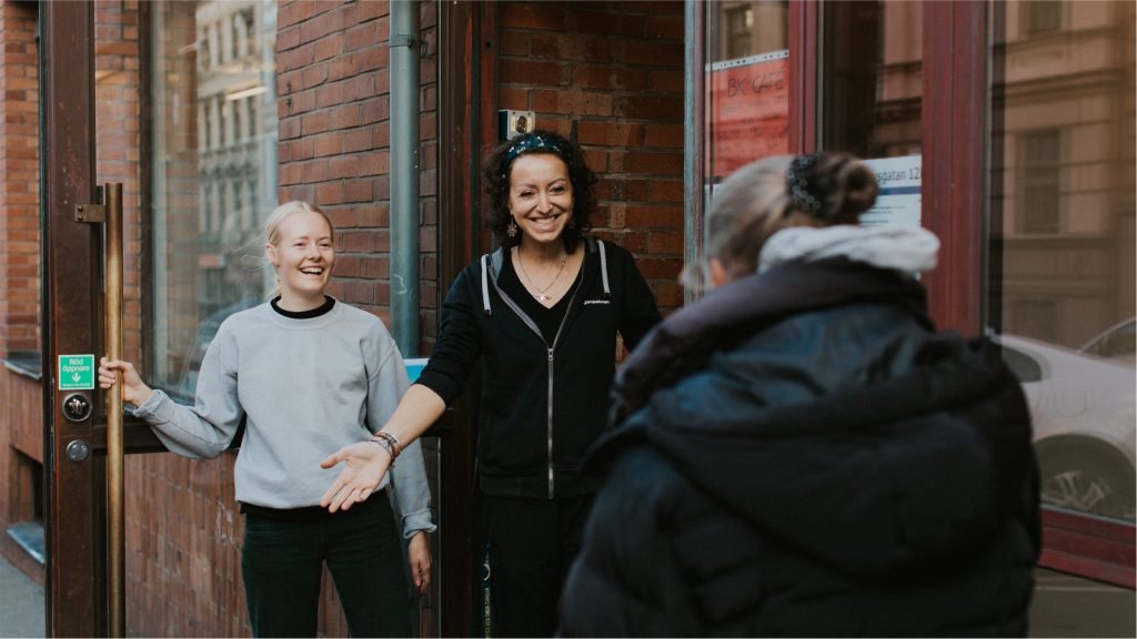 Two women standing outside a brick building.