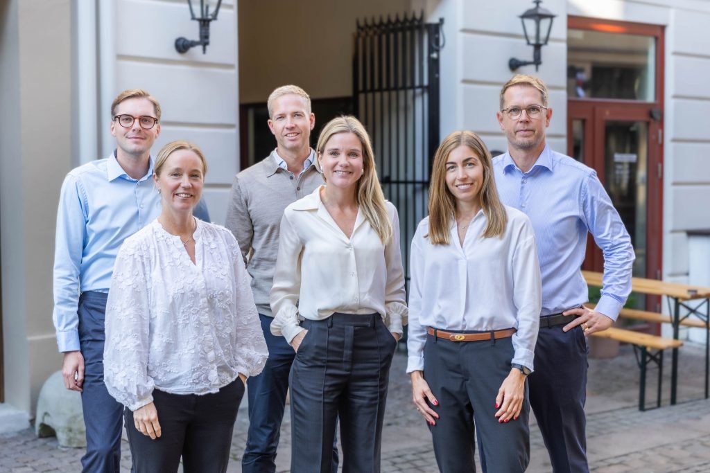 Group of colleagues posing outdoors in business attire.