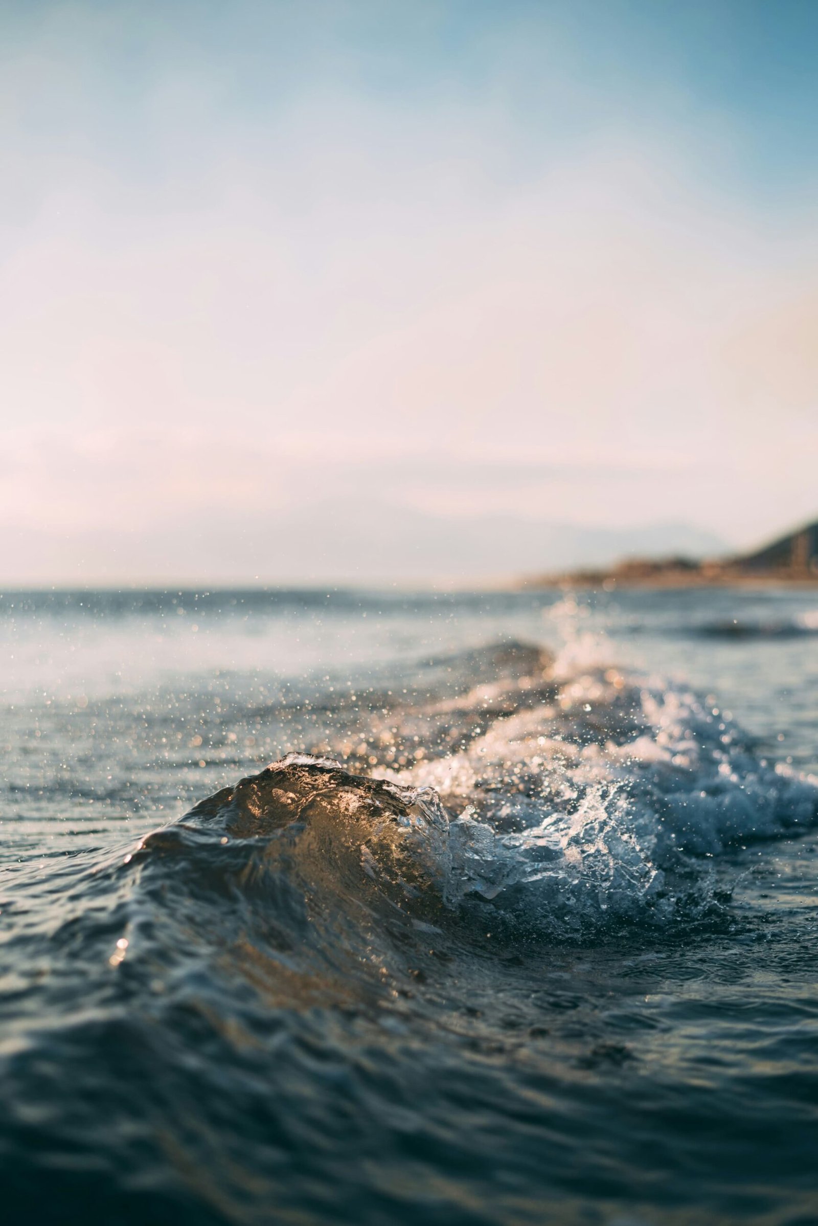 A wave in the ocean with the sky in the background.