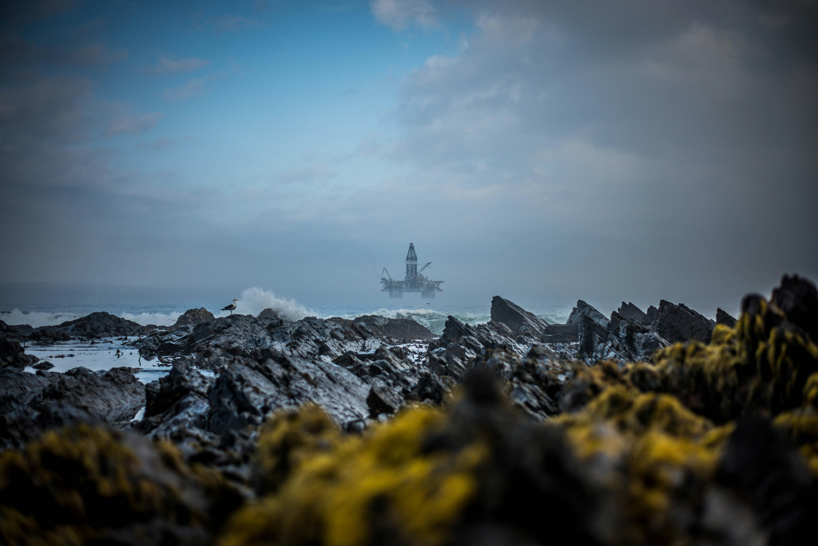 Industrial landscape with an offshore oil rig in the distance.
