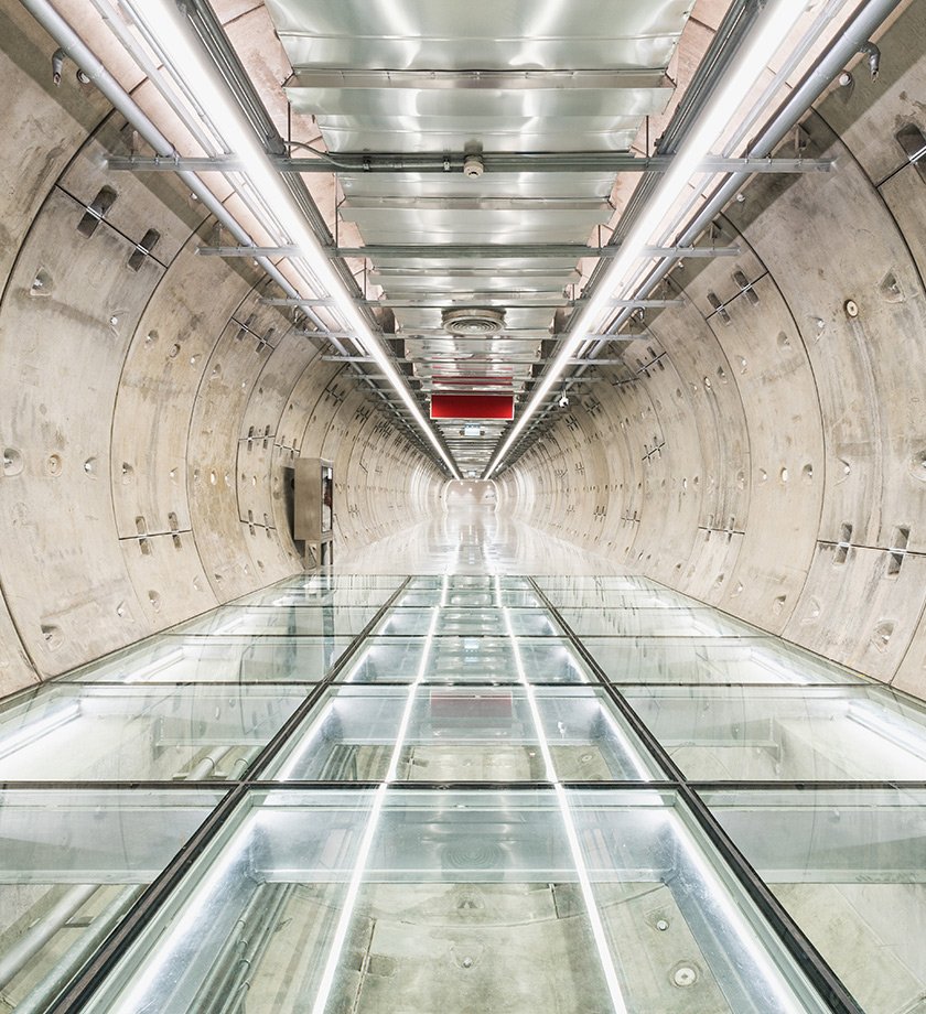 Underground facility with a long glass walkway.